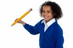 Pretty School Kid Facing Camera With Pencil In Hand Stock Photo