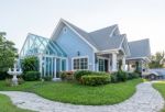 Bright Blue House In Sunlght With Colorful Poppies And Some Grac Stock Photo