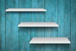 Three White Shelves On Blue Wooden Texture Background Stock Photo