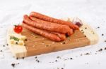 Wooden Chopping Board With Sausages And Spices Stock Photo