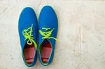 New Blue Sneaker On Textured Cement Floor Stock Photo