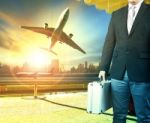 Business Man And Breifcase Standing In Airport Terminal Building And Passenger Plane Arrival On Runway Stock Photo