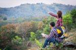 Female Tourists And Men Are Viewing The Mountain Stock Photo