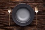 Black Empty Bowl Fork Spoon On Wooden Table Background Stock Photo