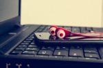 Earphones And Smart Phone On Laptop Stock Photo