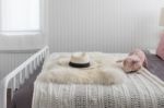 Pink Doll On White Wooden Bed And Classic Hat Stock Photo