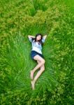 Asian Girl Laying On Green Meadow Stock Photo