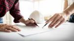 Architects Engineer Discussing At The Table With Blueprint - Clo Stock Photo