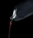 Red Motor Oil Lube Pouring From Black Plastic Bottle Stock Photo