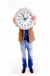 Front View Of Young Man Hiding His Face With Watch Stock Photo