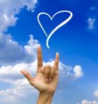 Gesturing Hand On Blue Sky Stock Photo