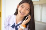 Portrait Of Thai Student Teen Beautiful Girl Using Her Phone And Smile Stock Photo