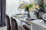 Table Set On Glass Dinning Table With Vase Of Flower Stock Photo