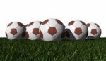 Brown Soccer Balls On A Green Grass Stock Photo