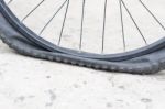 Bicycle Wheel With Flat Tyre On The Concrete Road Stock Photo