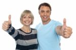 Confident Couple Showing Thumbs Up Sign Stock Photo