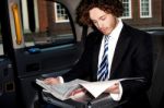 Male Passenger Reading Newspaper In Taxi Stock Photo