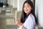 Portrait Of Thai Student Teen Beautiful Girl Using Her Phone And Smile Stock Photo