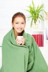 Woman Drinking Tea  At Home Covered With Blanket Stock Photo