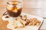 Glass Of Black Iced Coffee With Some Snack Stock Photo