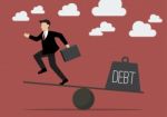 Balancing. Businessman And Debt Stock Photo