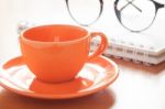 Close Up Of Coffee Cup With Book And Eyeglasses Stock Photo