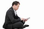 Young Man Sitting On A Floor And Using Tablet Pc Stock Photo