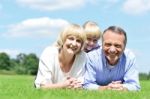 Lovable Family Of Three Lying In The Park Stock Photo