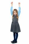 Cheerful Kid Raising Her Hands In Excitement Stock Photo