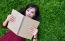 Woman Lying On Green Grass With  Book