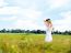 Woman At Wheat Field On Sunny Day