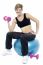 Woman Seated On Fitness Ball Doing Dumbbells