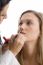 Young Pretty Beautician Applying Lipstick