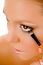 Close Up Of Female Putting Eye Liner