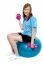 Pretty Teen Seated On A Blue Pilate Ball Doing Dumbbells