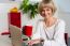 Cheerful Woman Holding Coffee Mug And Working