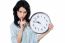 Young Brunette With Wall Clock Gesturing Silence