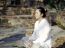 Asian Woman Meditating In Ancient Buddhist Temple