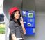 Happy Woman Calling From Public Phone