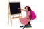 Cute Smiling Student Pointing At Blank Chalkboard