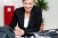 Smiling Businesswoman At Her Work Desk