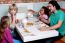 Cheerful Family Of Four Enjoying Breakfast