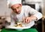 A Chef Arranging Tossed Salad In A White Bowl