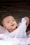 Portrait Close Up Face Of Asian Baby Lying On Bed And Playing Wi