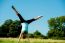 Woman Doing Cartwheel In A Field