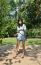 Woman Is Standing On A Swing In A Park Setting