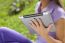 Tablet Computer On Hand Of Beautiful Young Woman In Park