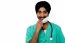 Smiling Male Doctor Removing Surgical Mask