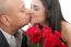 Close Up Of Couple Kissing Holding A Bouquet Of Red Roses