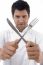 Chef Holding Crossed Fork And Knife